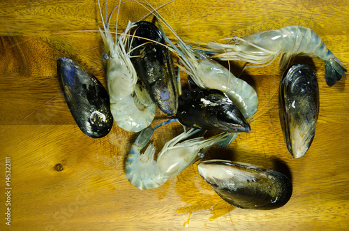 Blue New Zealand mussels and shrimp on the Wood background.