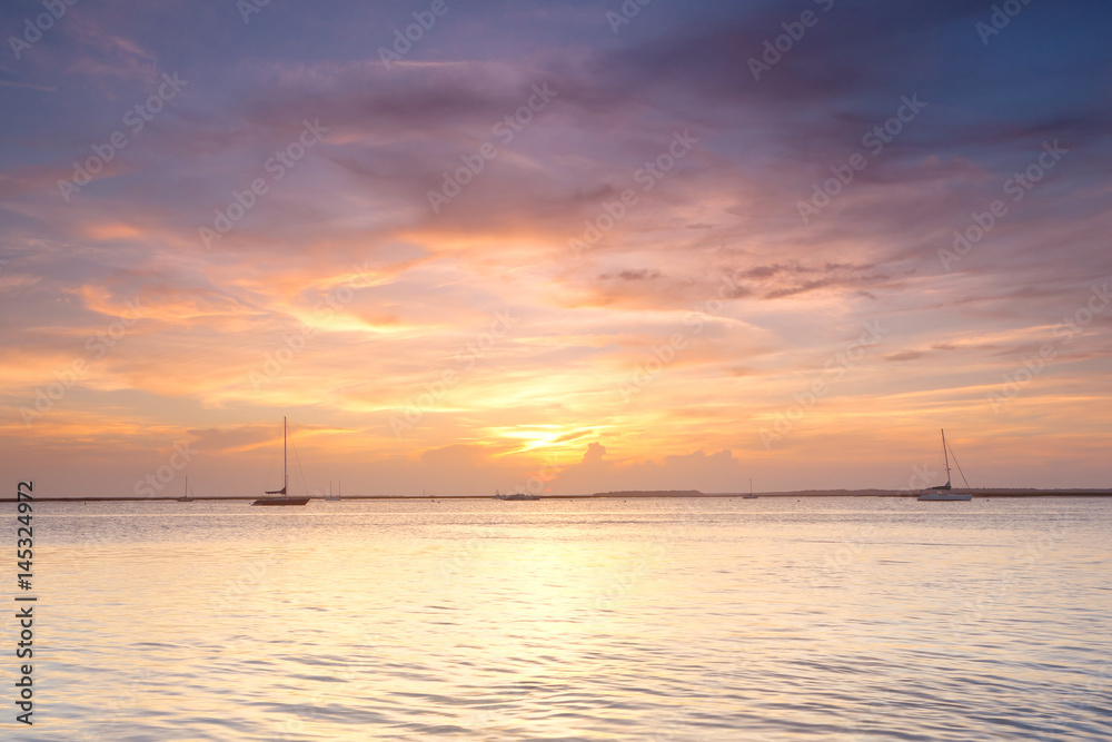Yachts in the ocean at sunset