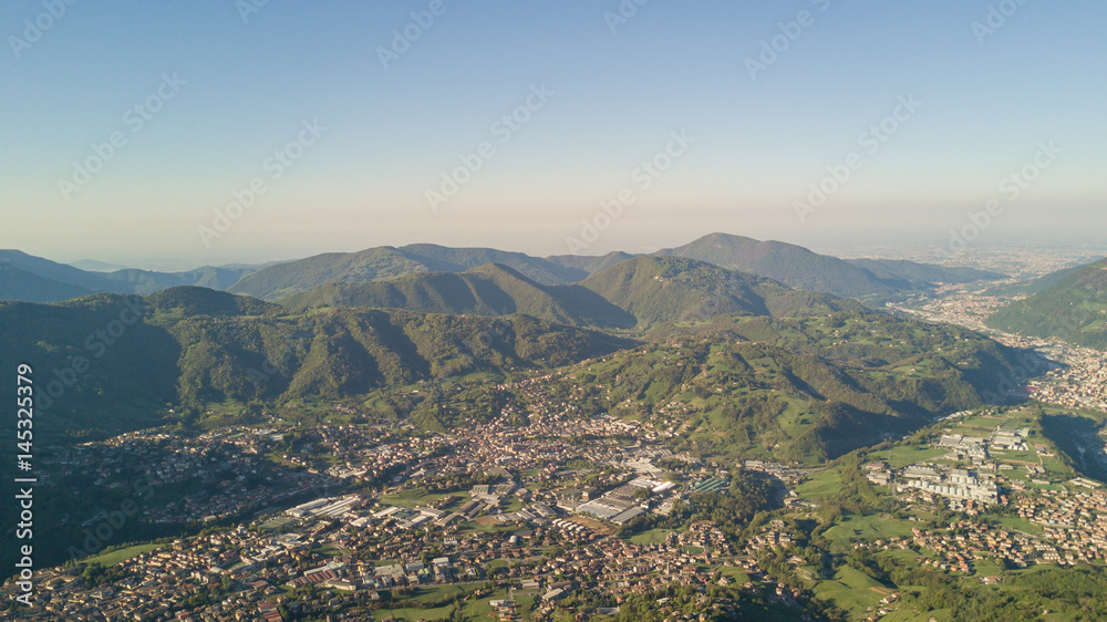 Drone aerial view to the Seriana valley in a clear and blue day. Panorama from Farno Mountain, Bergamo, Italy. 