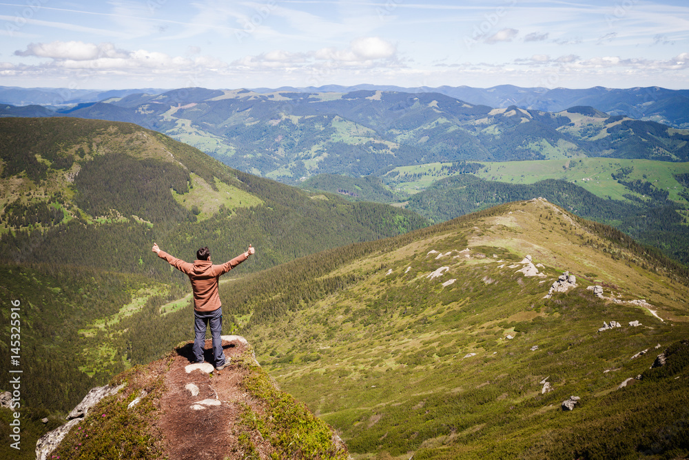 Summer mountain landscape with man standing on the rocky hill