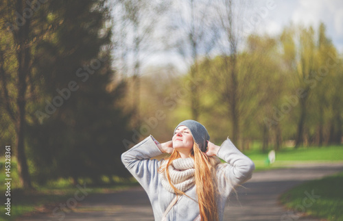 Fotografie Happy woman enjoying sun in park during early spring