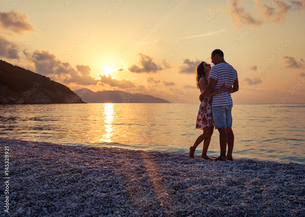 Fototapeta premium Young couple in love sitting on the beach