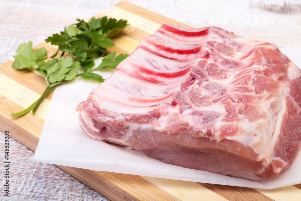 Raw pork chops, spices and basil on cutting board. Ready for cooking.