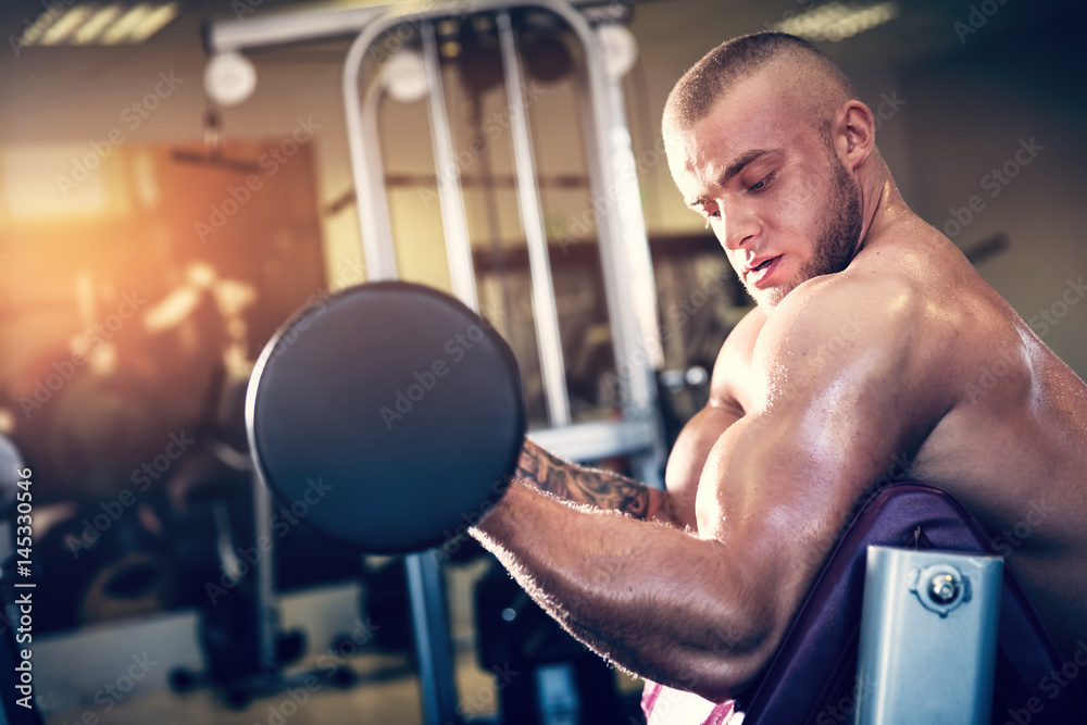 Muscular man working out at a gym. Muscular man working out at a gym.