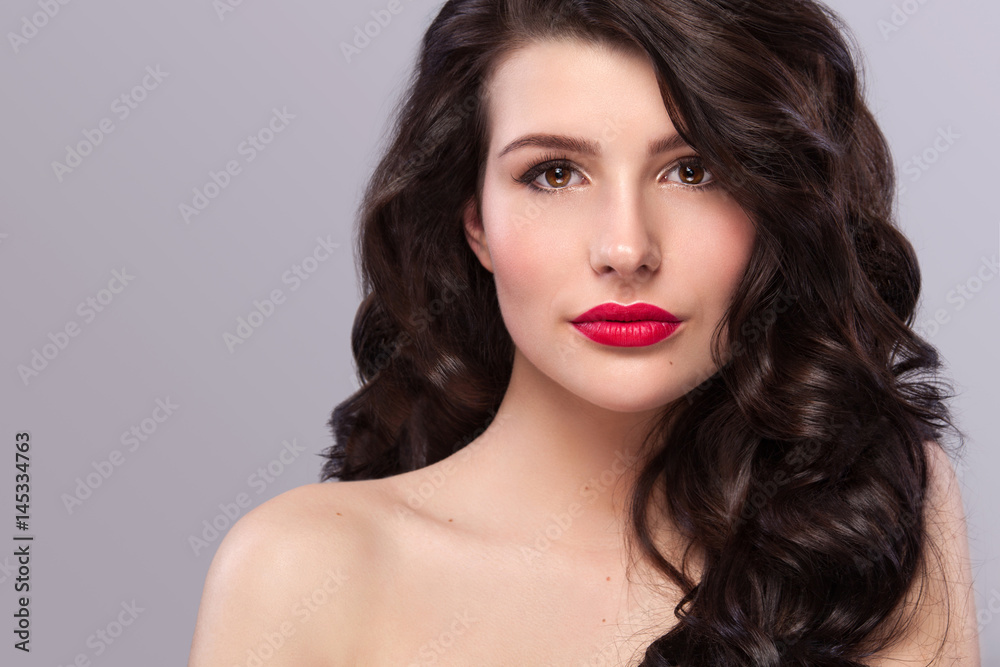 Sexy girl with long and shiny wavy hair . Beautiful model, curly hairstyle on gray background. Sexy girl with long and shiny wavy hair . Beautiful model, curly hairstyle on gray background.