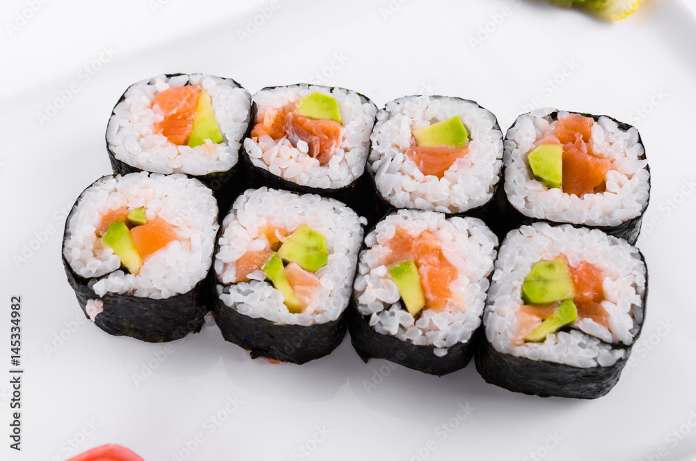 Asia. Rolls with salmon (red fish) on a white plate on a white background Asia. Rolls with salmon (red fish) on a white plate on a white background