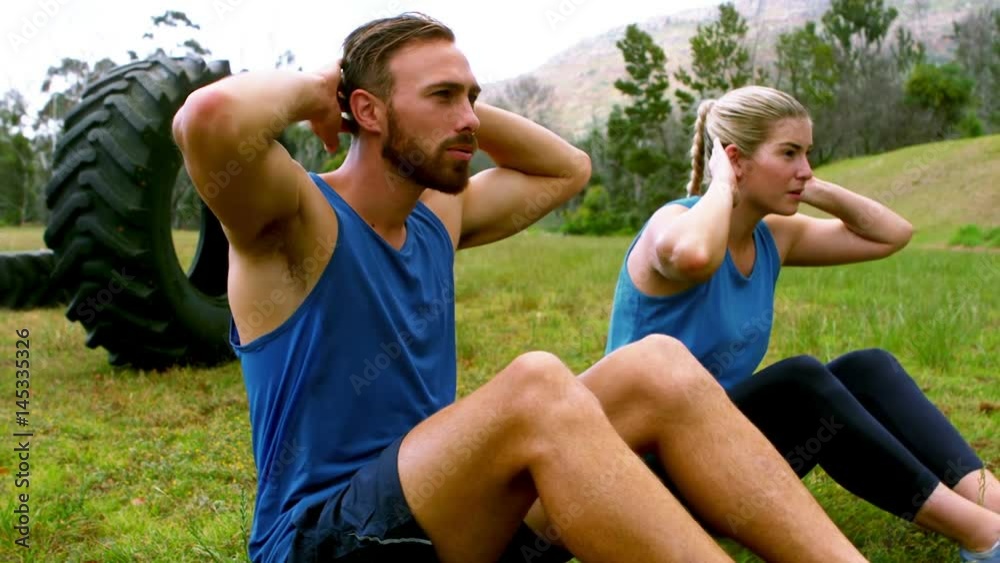 Couple doing abdominal crunches Couple doing abdominal crunches