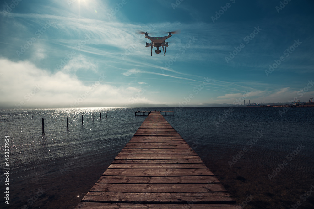 Flying drone, sea and wooden pier