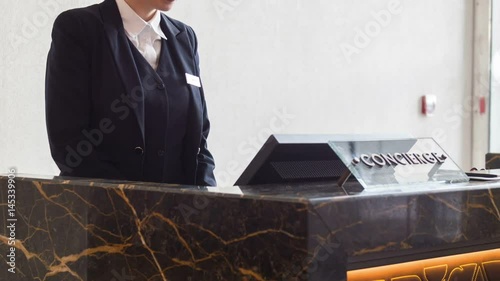 Positive female receptionist typing on computer