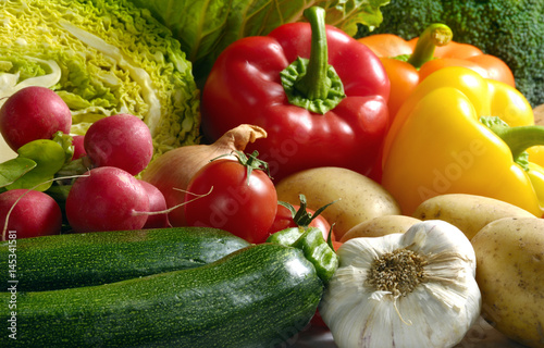 Various kinds of vegetables like zucchini, red radishes, peppers, salad, cabbage, potatoes, garlic 