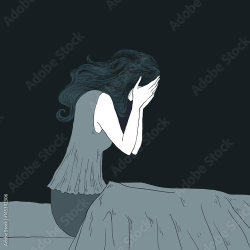 Nightmares / Insomnia concept. Young woman sitting in her bed crying, due to nightmares.