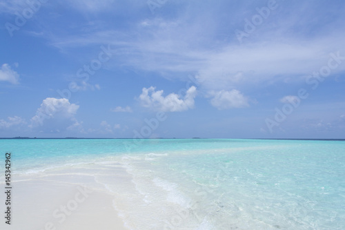 Tropical sand beach and blue sky with white clouds