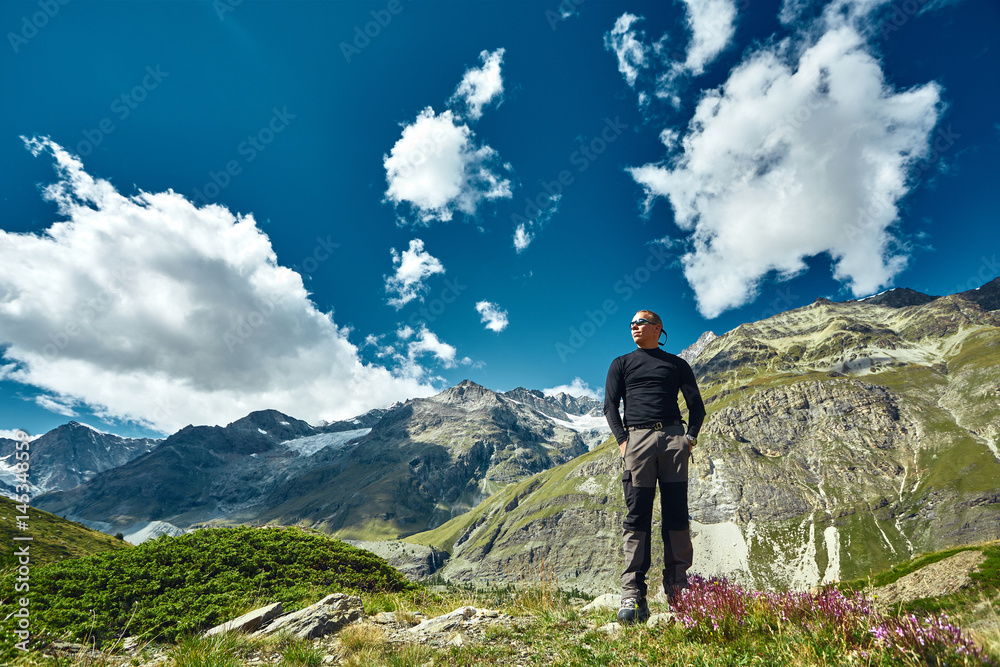 hiker on the trail against a blue sky in the Apls mountains. Trek near Matterhorn mount hiker on the trail against a blue sky in the Apls mountains. Trek near Matterhorn mount