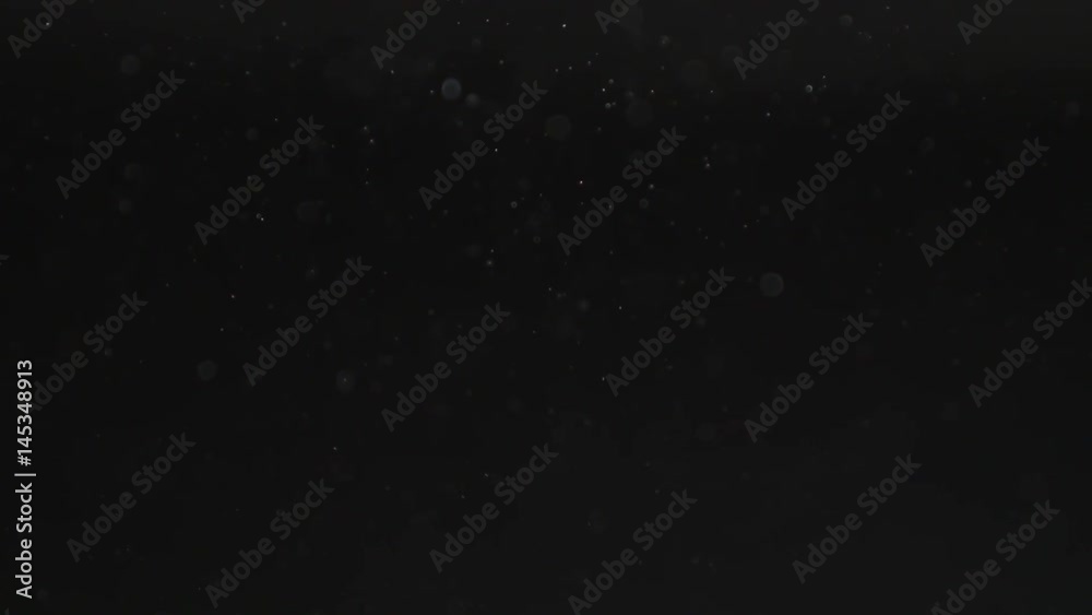 Slow motion of dust particles flow and float over black background, 180fps prores footage