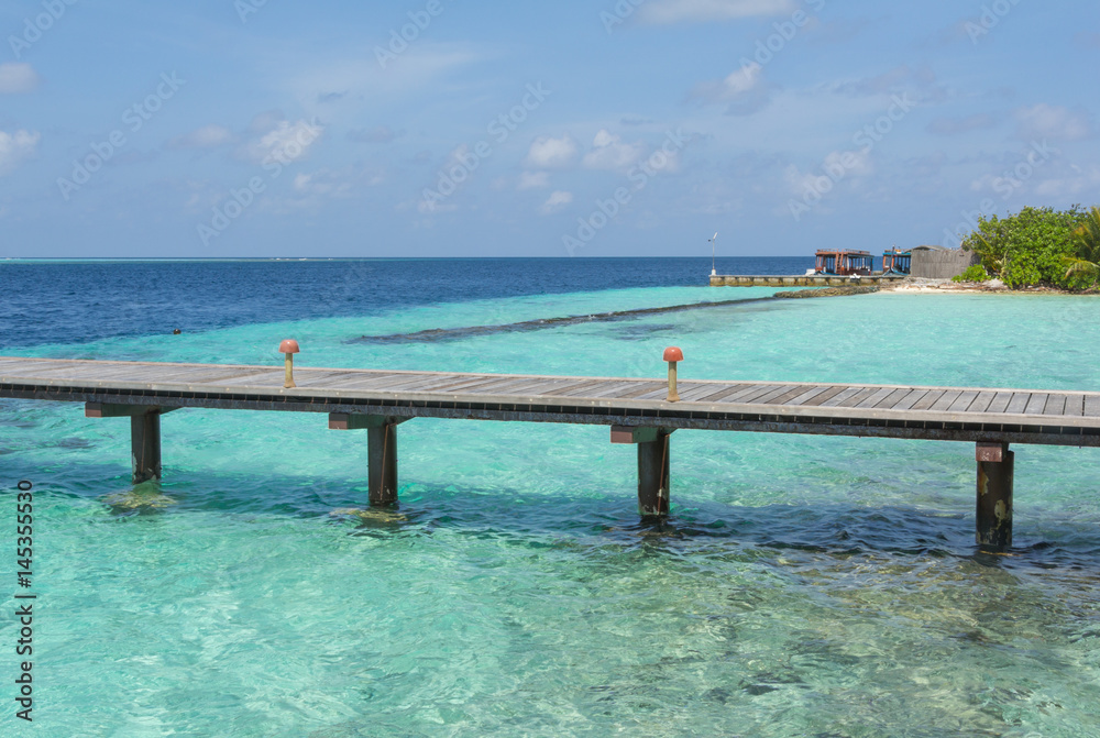 Wooden pier on a tropical beach in the Maldives Wooden pier on a tropical beach in the Maldives
