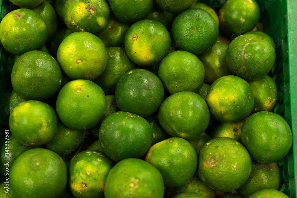 Bunch of fresh green mandarin in the organic food market. Tropical Bali island, Indonesia.