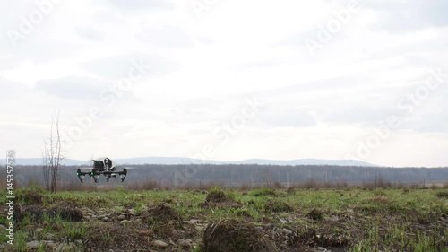 copter with camera started take off and flying on thefield photo