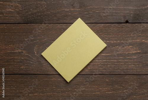 Yellow pack pile of stickers on the dark wooden rustic background for advertising diagonal mockup template