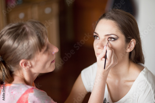 Make up artist doing makeup for model 