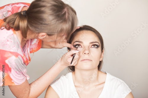 Make up artist doing makeup for model 