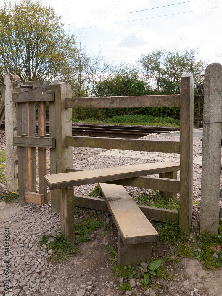 The Wooden Crossing Over A Railway Track, the Planks To Cross Over the Path with Gate and Fence The Wooden Crossing Over A Railway Track, the Planks To Cross Over the Path with Gate and Fence