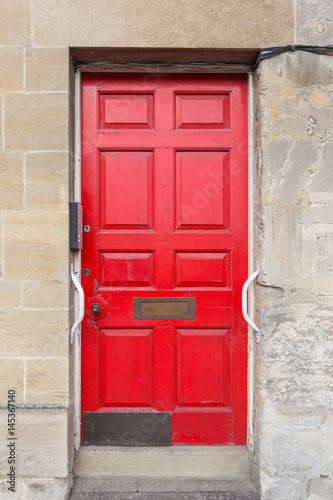 old and rustic red European door © kudosstudio