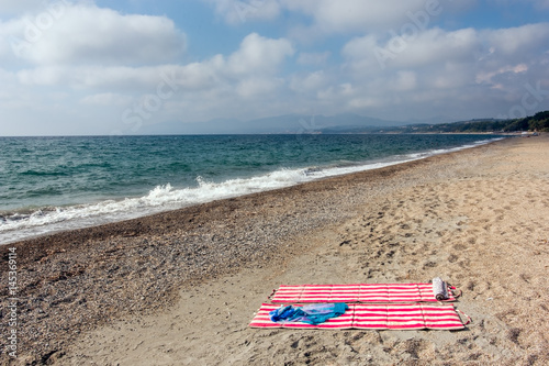 Beach mattresses and scarf on the seaside beach in Greece