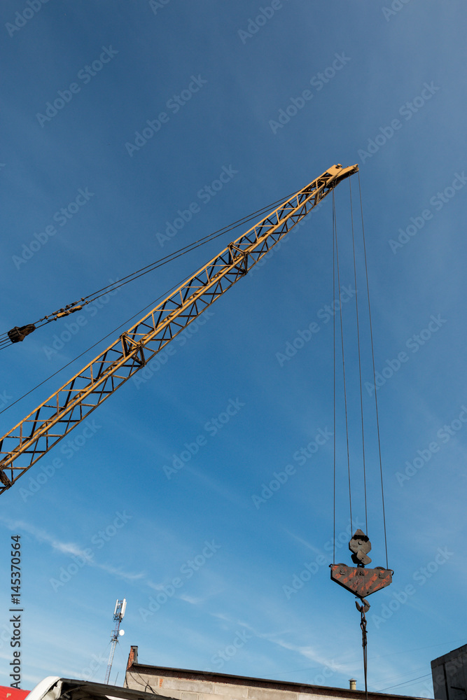 Arrow of a construction crane against a blue sky background