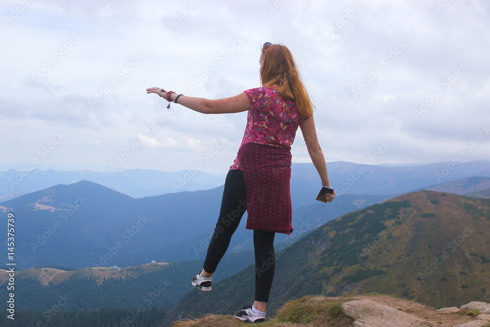 Girl standing on edge of mountain, enjoying beautiful sunset at Carpathians Girl standing on edge of mountain, enjoying beautiful sunset at Carpathians