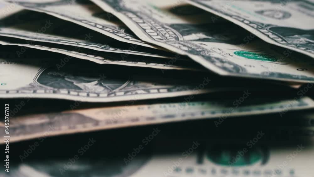 lot of small dollar bills swaying in the wind on the table with a white background macro close up lot of small dollar bills swaying in the wind on the table with a white background macro close up