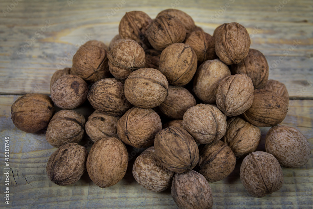 Group walnuts in shell on a wooden background Group walnuts in shell on a wooden background