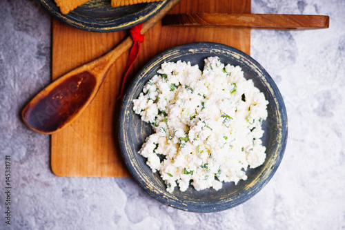 Cottage cheese in a dish and wooden spoon