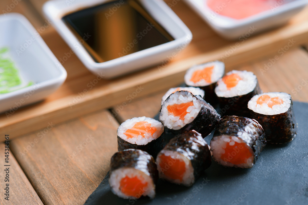 Sushi rolls with salmon and dishes with soy sauce, wasabi and ginger Sushi rolls with salmon and dishes with soy sauce, wasabi and ginger