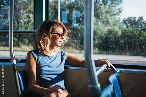 Young woman riding a public bus on a sunny day