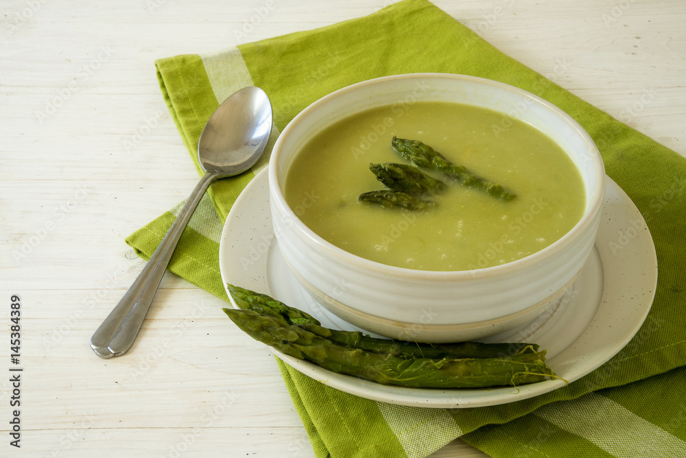 soup from green asparagus in a bowl on a green napkin and a white wooden table, copy space, selected focus, narrow depth of field soup from green asparagus in a bowl on a green napkin and a white wooden table, copy space, selected focus, narrow depth of field