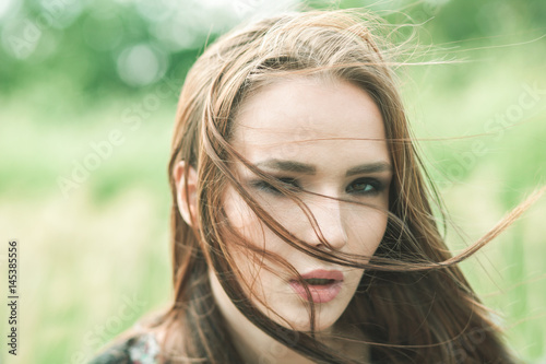 close up portrait of woman at windy day outdoor, nature background