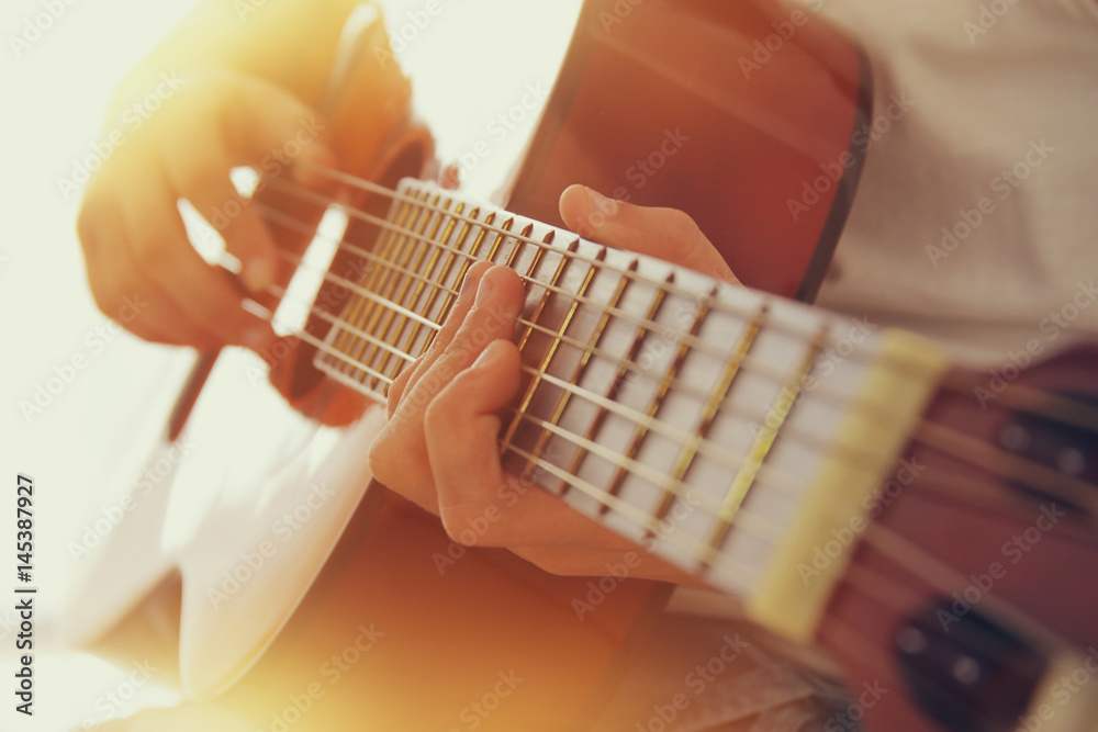 Naklejka premium Zamknij się młoda dziewczyna gra na gitarze akustycznej