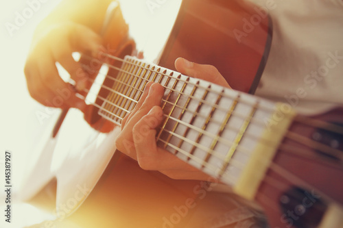 Fototapeta Zamknij się młoda dziewczyna gra na gitarze akustycznej