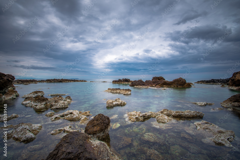 Long exposure at sunset with calm sea and rocks, Crete, Greece.