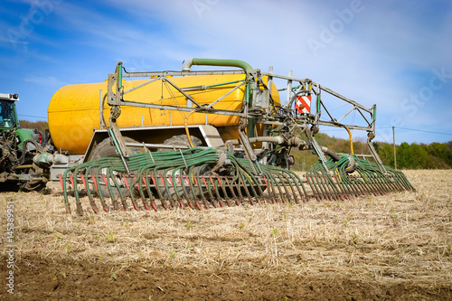 Tractor with vacuum manure spreader on a field
