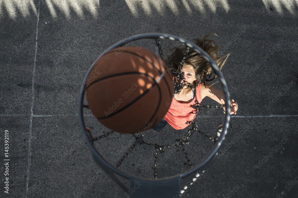 Naklejka premium Young woman playing in basketball