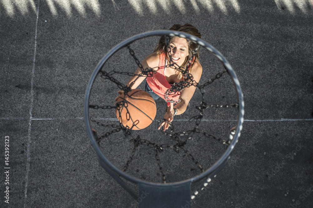 Naklejka premium Young woman playing in basketball