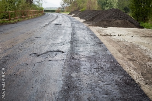 Road repair concept. Old damaged asphalt road, milling and asphalting. Preparation of the substrate.