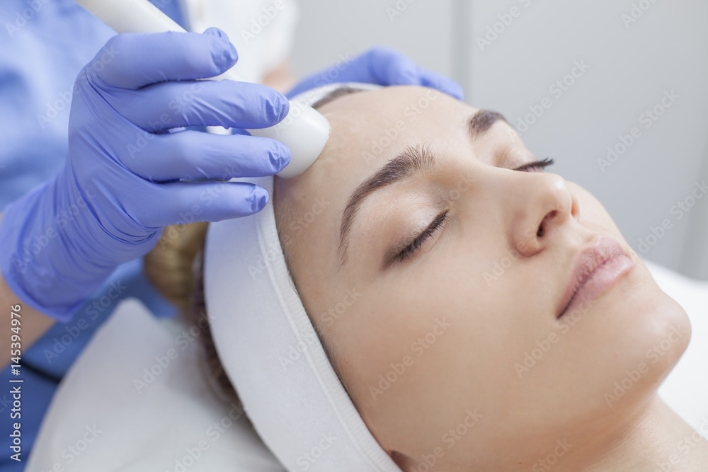 Face skin care. Woman getting facial laser treatment
