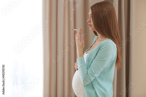 Pregnant woman smoking ciga...