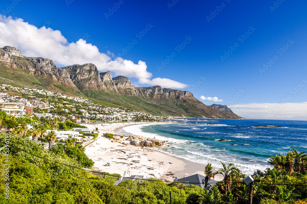 Stunning photo of Camps Bay, an affluent suburb of Cape Town, Western Cape, South Africa. With its white beach, Camps Bay attracts many tourists. Twelve apostles mountain range in the background.