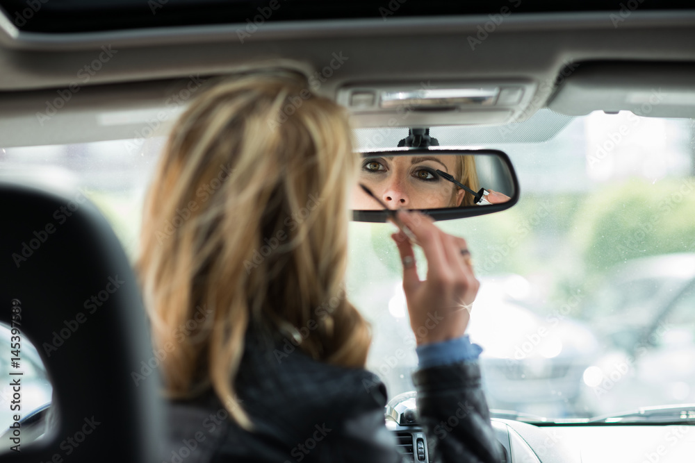 Woman applying make-up in car Woman applying make-up in car