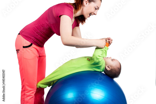 Obraz na plátně A mother and baby doing gymnastic exercises on the ball