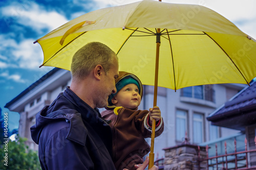 Father and son under an umbrella