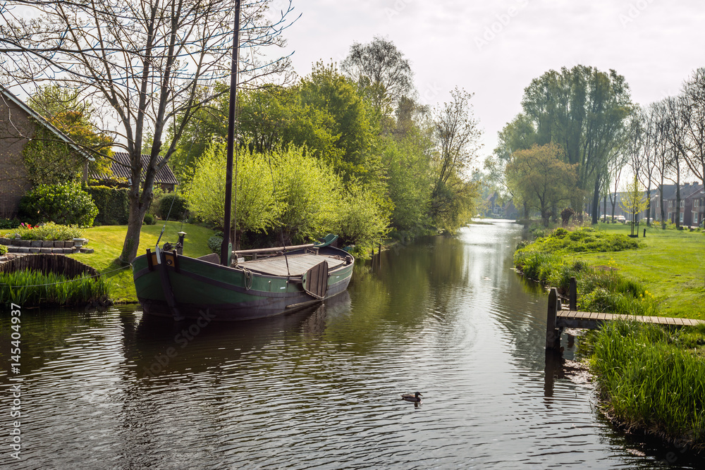 Canal with ship in a small Dutch village Canal with ship in a small Dutch village